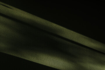 Background of a dark wall with a ray of light on it