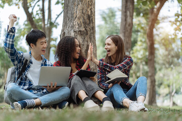 Happy group of college students use laptop feel excited overjoyed with good news over smartphone or Tablet.