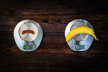 Ripe fresh and dried banana on the scales. concept of weight loss. Dried sweet on wooden background