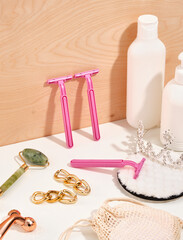 Skin care ingredients, accessories. Pink razors, facial cleansing gels, facial roller massagers for youth, jewelry earrings and shining tiara.