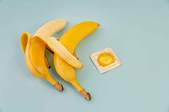 two bananas and a condom on blue background, sex concept