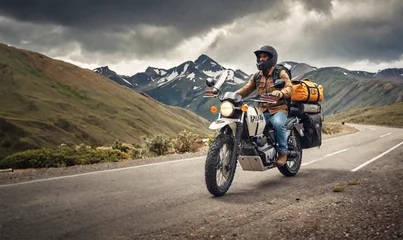 Fotobehang Adventurous motorcycle rider on the road on a motorcycle with camping bags © HappymanPhotography