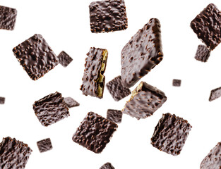 Cookies coated with chocolate and nuts fly and levitate in space. Surround light from behind. Isolated on white.