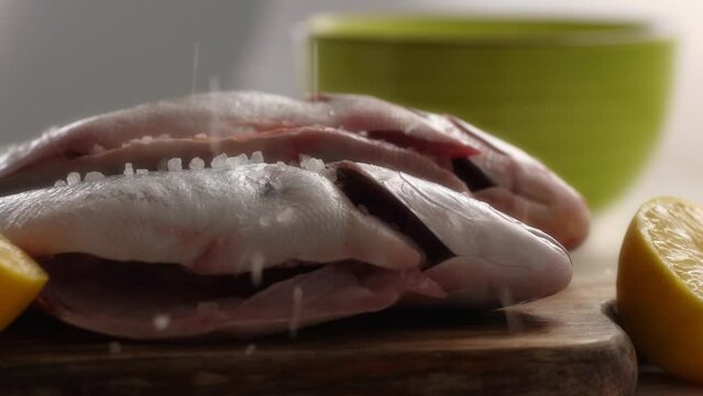 Seasoning Fish with Salt and Lemon for Cooking. Close-up, shallow dof.