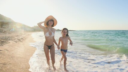 mother and son run along the sandy beach at sunset. family vacation on the beach. concept of traveling with children. - Powered by Adobe