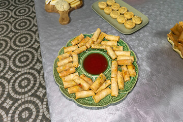 Vibrant veggie rolls with tangy sweet sauce on a party table.