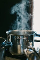 A pot with food cooking on the stove. Steam over the pot.