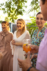 Group of beautiful happy people communicating and smiling while spending time on weding outdoors part