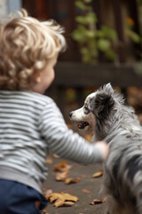 A child plays dynamically with a dog in the nursery. Motion blur.