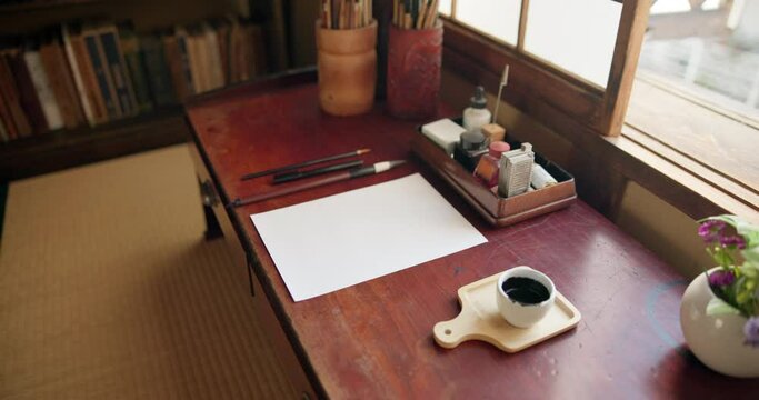 Art, paper and calligraphy tools in artist studio with creative brushes, pencil and ink for illustration. Japanese sumi, document and home isolated with drawing, creation and creativity for painting