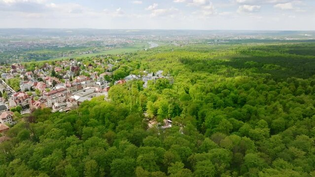 Aerial flight over the green Dresden Heide with the district of Dresden Loschwitz in summer.