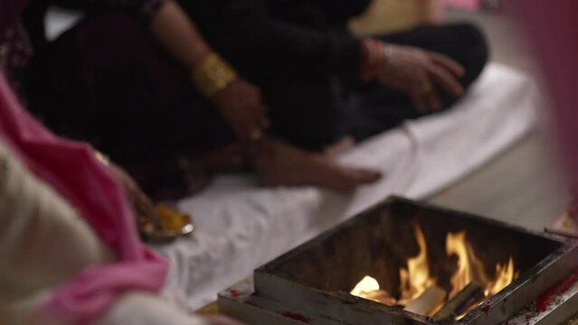 The Indian groom inserts ghee into the sacred marriage fire, symbolizing the nourishment of their union with purity and devotion.High quality footage