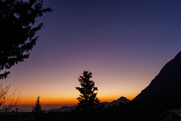 Silhouette of a mountain and a tree against the background of dawn.  Antalya. Turkey.