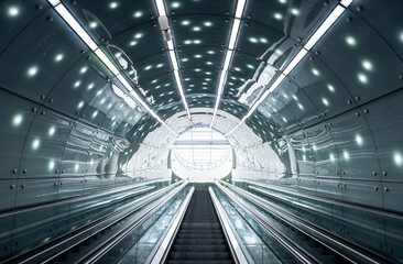 Futuristic interior: escalator moving staircase upwards inside round illuminated tunel
