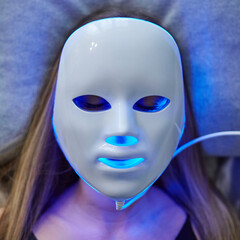 Woman with led light therapy facial beauty mask photon therapy. Home skin care