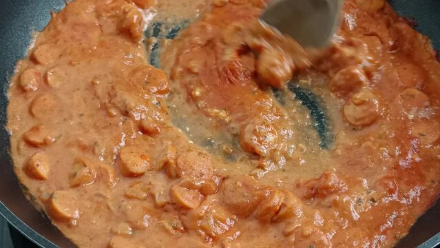 cuisson de sauce aux saucisses et &agrave; la tomate dans une po&ecirc;le