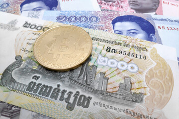 Bitcoin on a stack of Cambodian riel banknotes