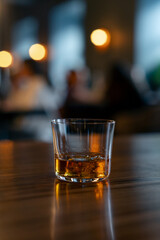 Single glass with rum in the restaurant. Glass of expensive alcoholic drink with ice cube