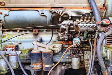 Close-up of very old engine with cylinders, filters, crankshaft, hoses, connections, valves, tappet, cables, structure corroded, rusty and dirty due to passage of time