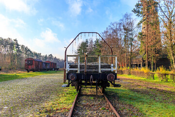 Old train station, flat car with coupling stops or bumpers on disused tracks, freight cars in...