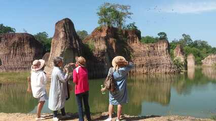 4 Asian women retired standing and looking at the natural view in national park, Senior best friend enjoyed journey in vacation, Group entrepreneur elderly meeting outdoor and enjoy activity.