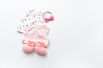 Flat lay of pink baby clothing and accessories. Kids bodysuit and shoes flat lay