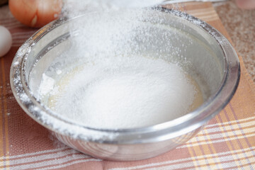 Fototapeta na wymiar Sifted flour is poured into a bowl....