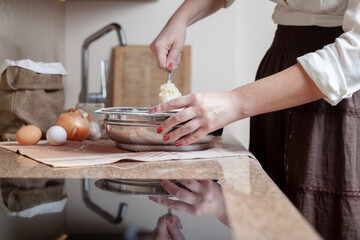 Woman stirring dough in bowl with spoon....