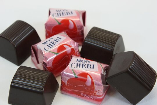 Nahaufnahme von einzelnen Mon Cheri Lik&ouml;r-Kirsch-Pralinen der Firma Ferrero auf wei&szlig;em Hintergrund