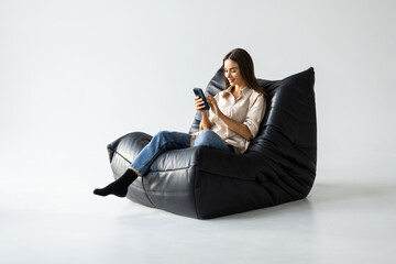 portrait girl chatting holding phone in two hands sitting in beanbag chair i