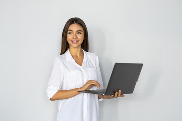 Portrait of a happy businesswoman working on laptop computer isolated over white background