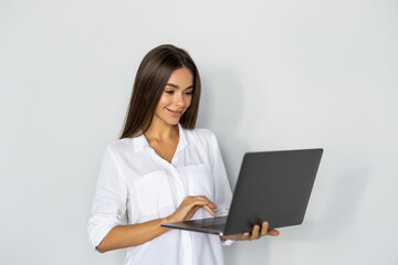 Portrait of a happy businesswoman working on laptop computer isolated over white background