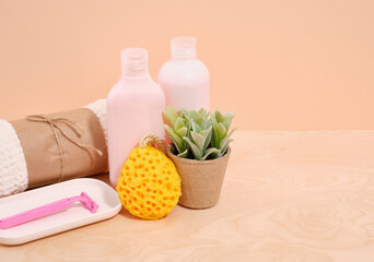 Clean towel, razor, bathing gels and yellow washcloth. Copy space for text.