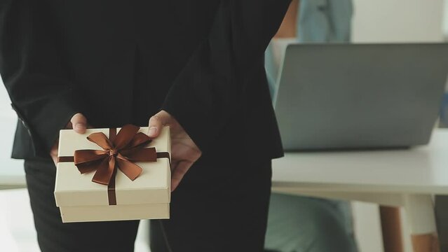 Close up view of Young Asian business woman receiving salary or bonus money from boss or manager at office happily.