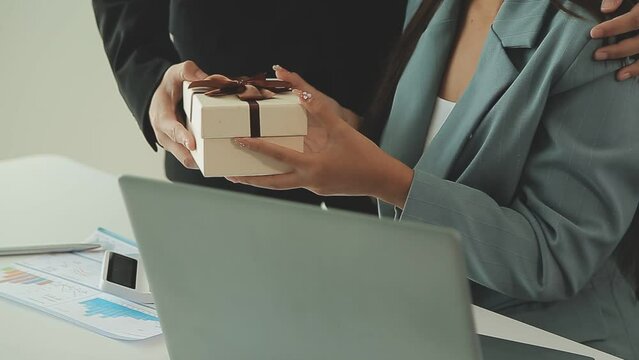 Close up view of Young Asian business woman receiving salary or bonus money from boss or manager at office happily.