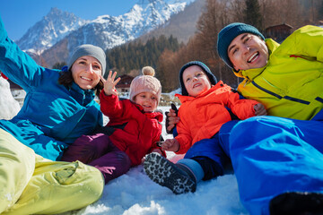 Fototapeta na wymiar Cheerful family portrait on winter holiday in sunny mountains