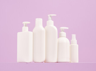 White dispensers with various shower gels and shampoos stand in a row. Cosmetic cleaning and care products.