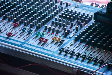 Sound engineer using mixing console to produce a sound track.