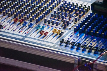 Sound engineer using mixing console to produce a sound track.