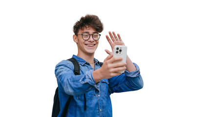 Cheerful teen boy in glasses, jeans shirt makes video call by phone waving hand saying hello, toothy smiles standing against transparent background. Caucasian youngster talking to parents