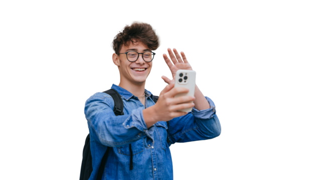 Cheerful teen boy in glasses, jeans shirt makes video call by phone waving hand saying hello, toothy smiles standing against transparent background. Caucasian youngster talking to parents