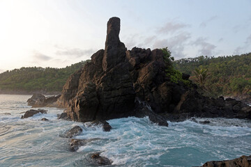 Beautiful rocky beach of East Java, Indonesia in the late afternoon. Low light landscape photography.