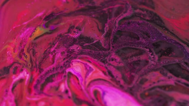 Neon paint swirl. Oil fluid texture. Magic potion. Defocused fluorescent purple pink color glowing shiny ink liquid bubbles flow motion abstract art background.