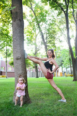 Obraz premium Woman exercising with her baby girl in the park