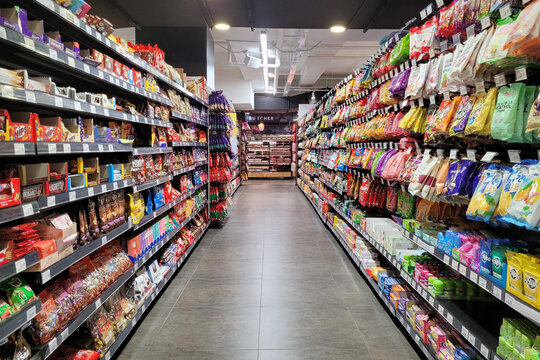 PENANG, MALAYSIA - 5 DEC 2023: A variety of local and imported snacks, candies, and chocolates are showcased on the store shelf at Mercato grocery store.