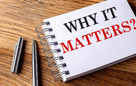 WHY IT MATTERS text on notebook with pen on wooden background