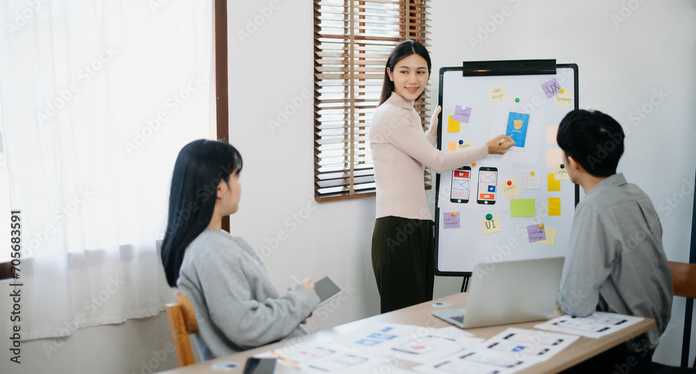 Wall mural close up view of ui developer team brainstorming on their project with laptop, smartphone and digita
