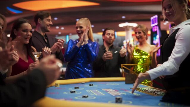 Happy and Cheerful Group of Casino Guests Placing Bets and Celebrating Winning Luck and Skill in Baccarat. Glamorous Gamblers Having Fun and Playing a Card Game in Private Club. Slow Motion
