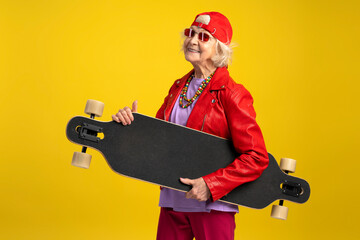 Grey hair modern urban caucasian woman with skateboard looking at camera