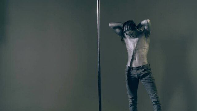 Sexy man pole dancer. Guy does gymnastic exercises on pole dance. Pole dancing for slim fitness body. Flexibility. Pole dance. Pylon dancing strength, flexibility, and grace. Strip dancer.